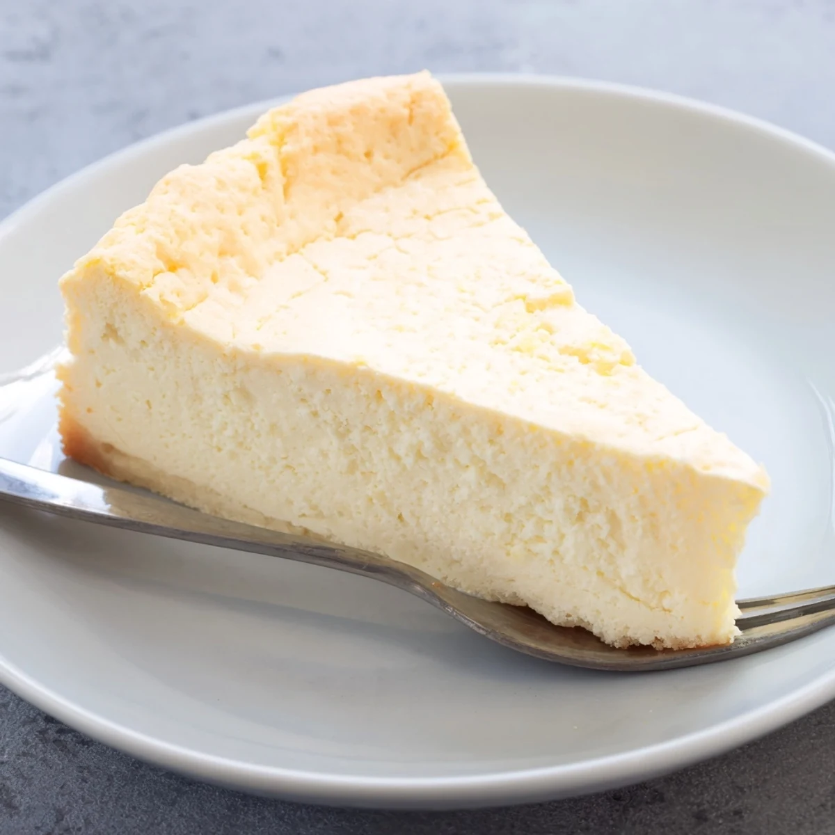 Luftige Quark Cheesecake mit zarter Textur, serviert mit frischen Beeren.